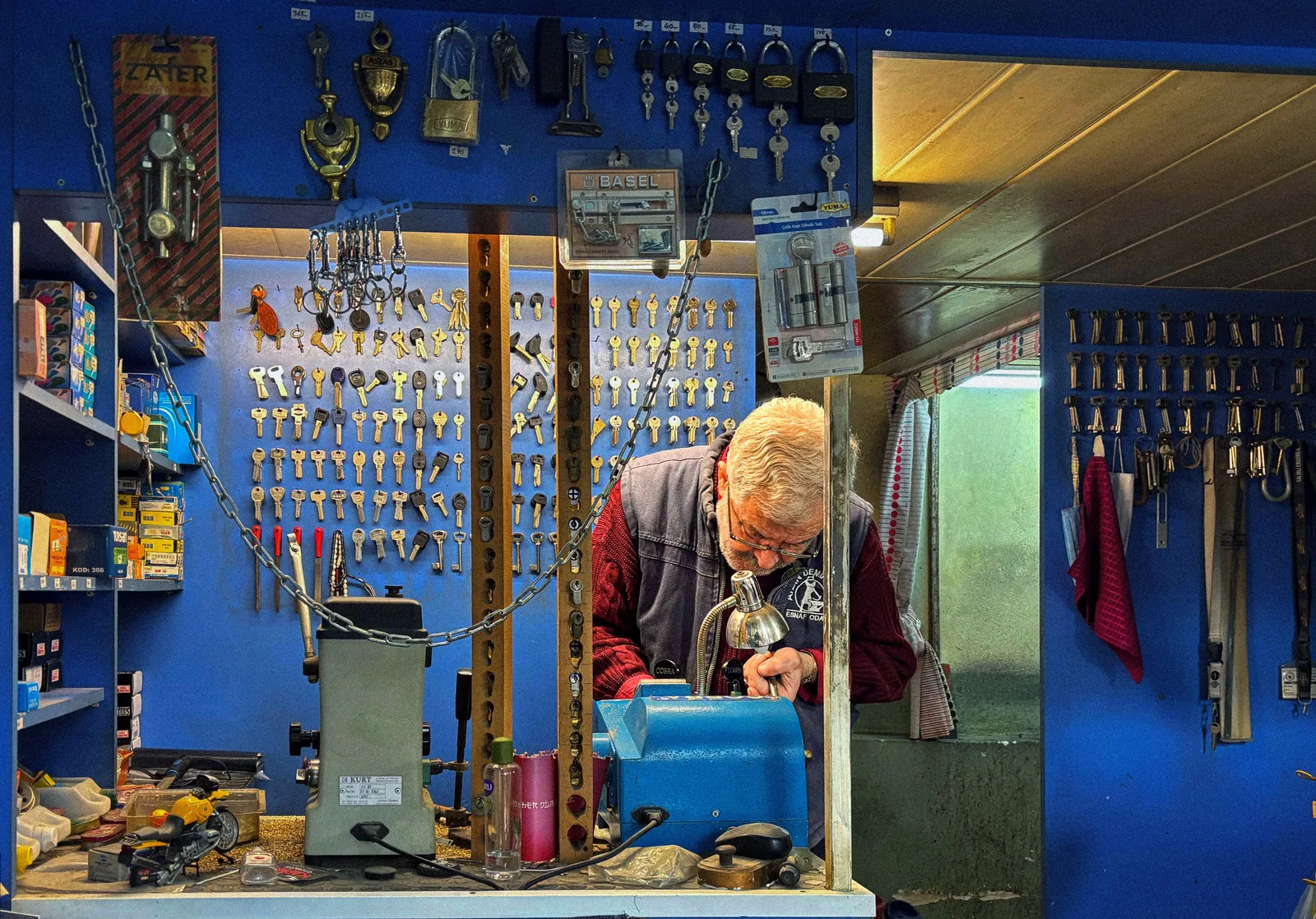 A senior locksmith crafts a key in his hardware shop filled with locks and keys. Locksmith profit margin: the break-even formula