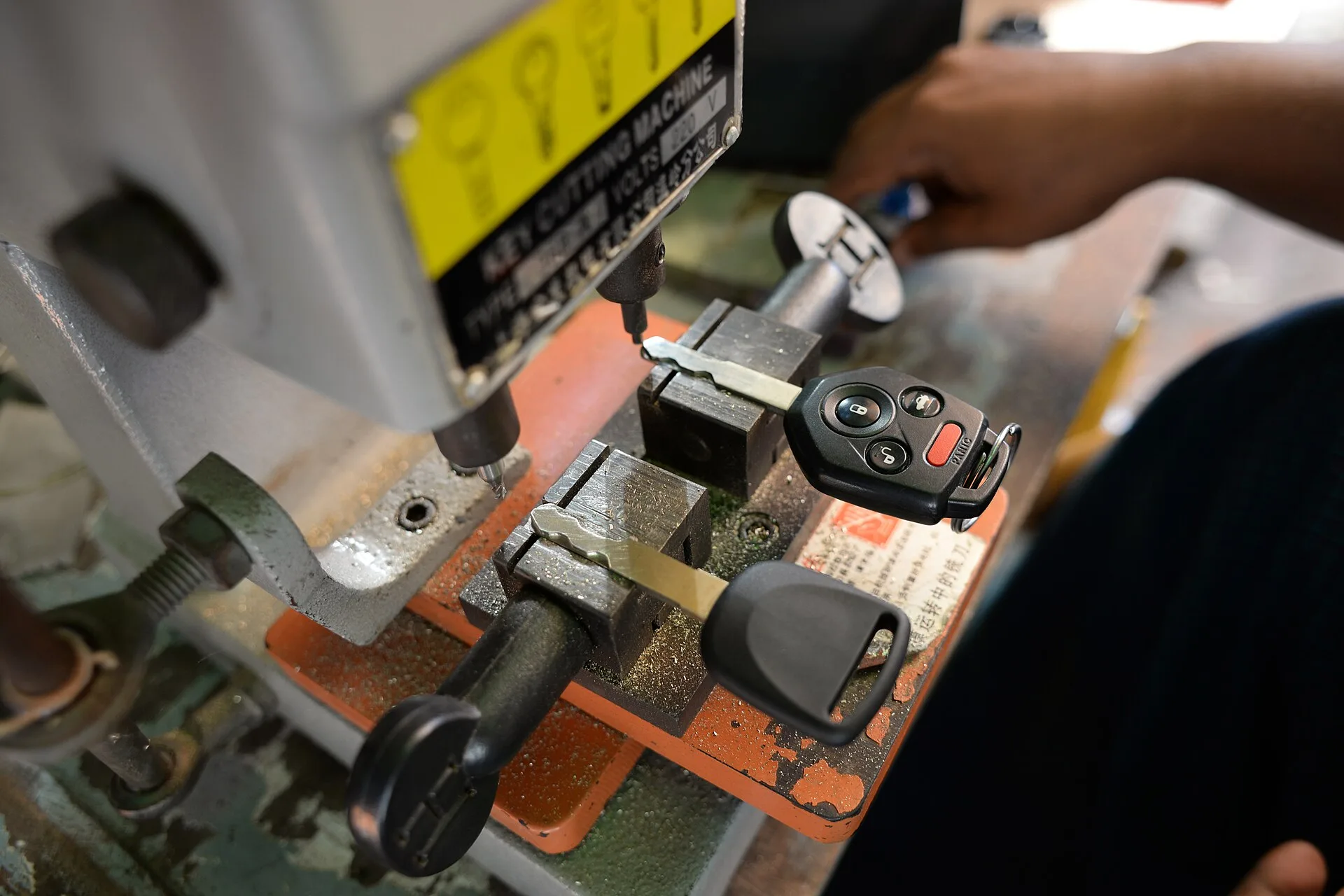 Car key being duplicated with a key cutting machine. The startup budget for a locksmith business and the ways to finance it